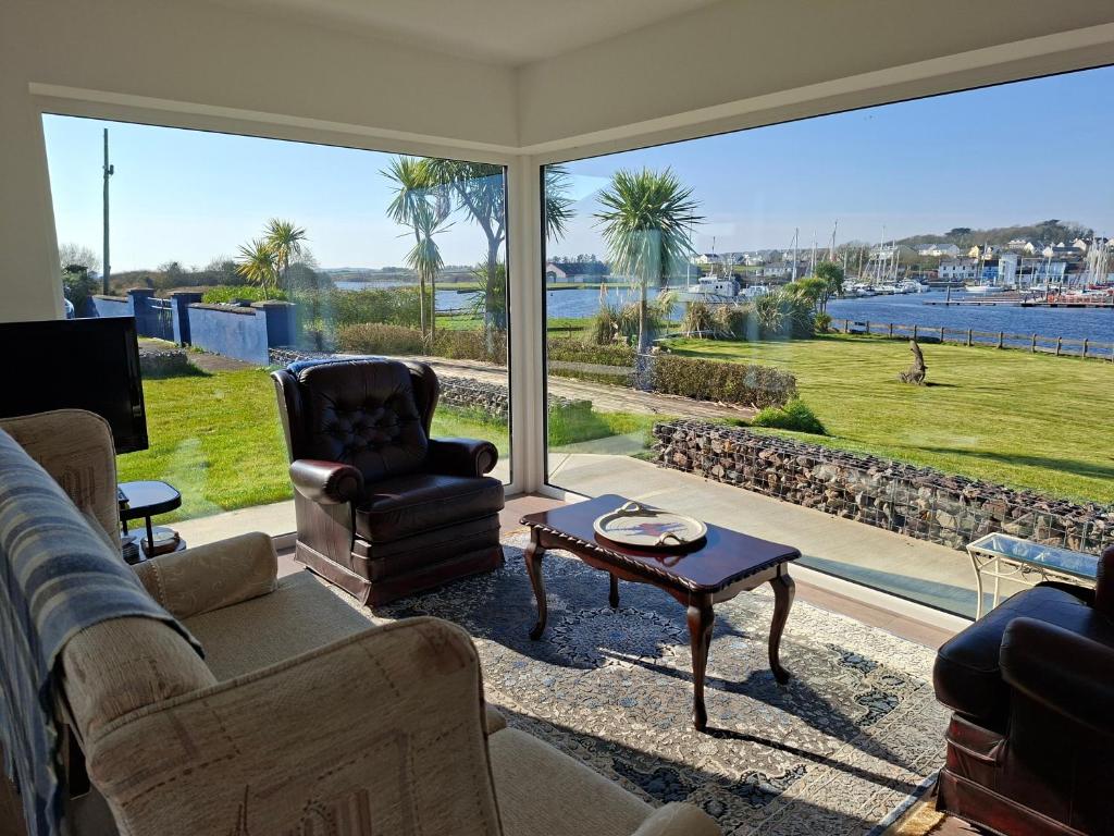 a living room with a large window with a view of the water at Ferry Lodge Cottage in Kilrush