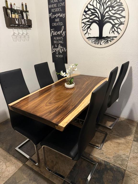 a dining room table and chairs with a tree on the wall at Comfort House in Manuel F. Martínez
