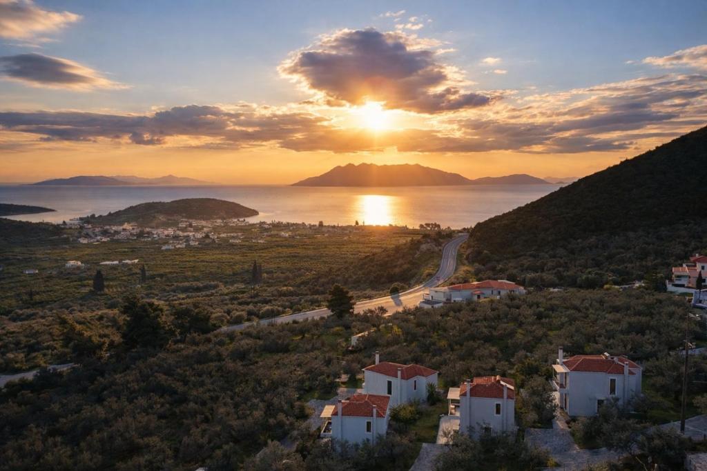a sunset over the ocean and a small town at Epidavros View Villas in Ancient Epidauros