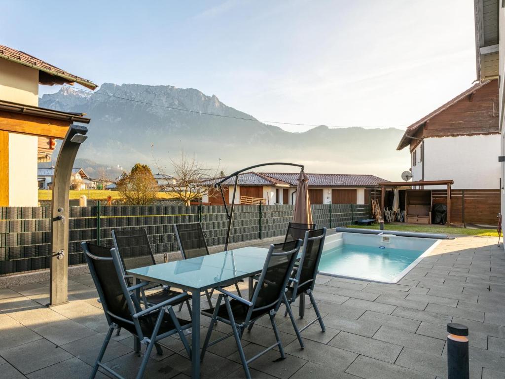 a patio with a table and chairs next to a pool at Kaiser Chalet Ebbs in Ebbs