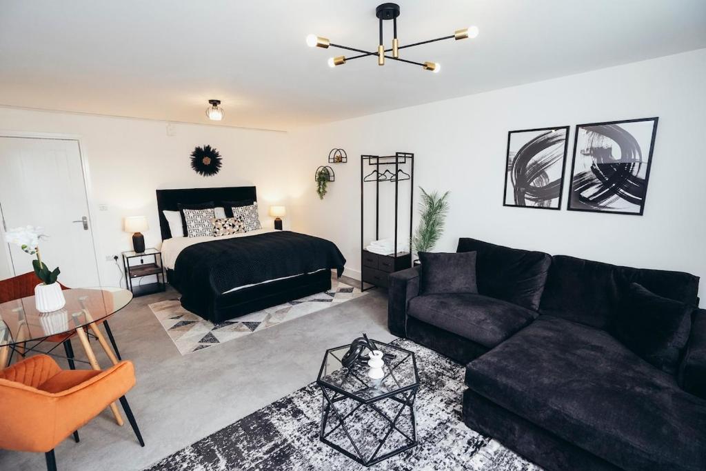 a living room with a black couch and a bed at Queensferry Collection - Residence 2 in Derby