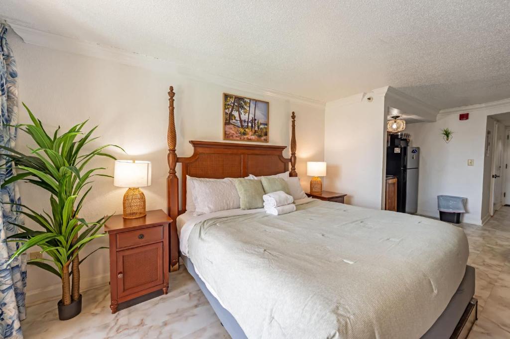a bedroom with a large bed and a plant at Amazing View Ocean Front Studio Nicely Decorated in Myrtle Beach