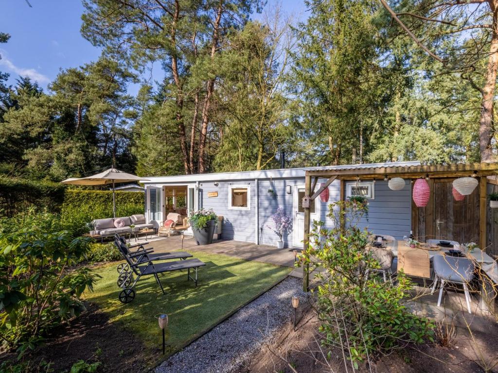 a tiny house in a garden with a patio at Boschalet Stijn in Hattemerbroek