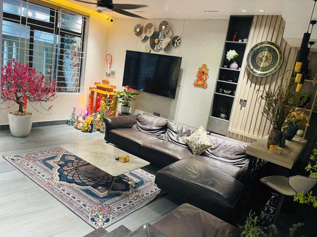 a living room with a leather couch and a tv at Win Home Huế in Hue