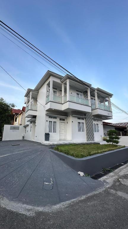 a large white house with a driveway in front of it at Villa Shafa Marwa in Bukittinggi