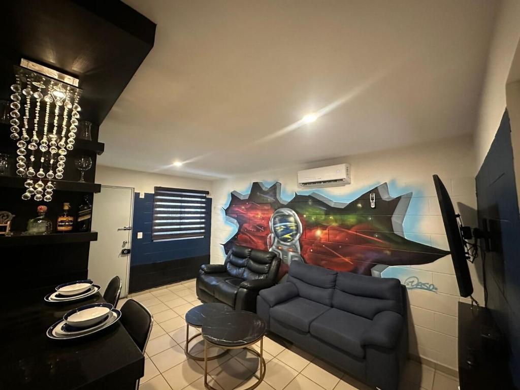 a living room with a couch and a painting on the wall at Acapulco in Mazatlán