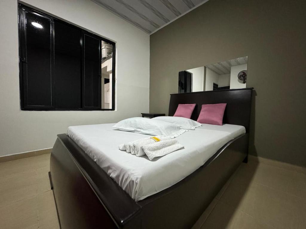 a bedroom with a large bed with pink pillows at HOSPEDAJE CASANOVA FlORIDA VALLE in Florida