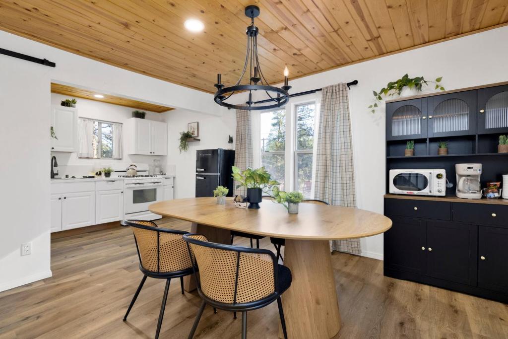 a kitchen with a wooden ceiling and a wooden table and chairs at Shiloh Woods Cabin Walk to Lake & Village Fireplace Cozy Retreat in Big Bear Lake