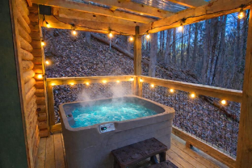 a hot tub in a tree house with lights at Timber Wood, Log Cabin, Private Hot Tub, WiFi, Fireplace in Sevierville