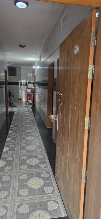 a hallway with wooden doors and a tile floor at Shanti villa in Kadipur