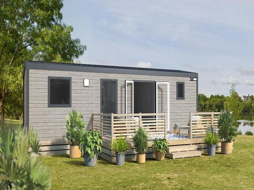 a tiny house with potted plants in a yard at Mobile home Keiheuvel 6p in Balen
