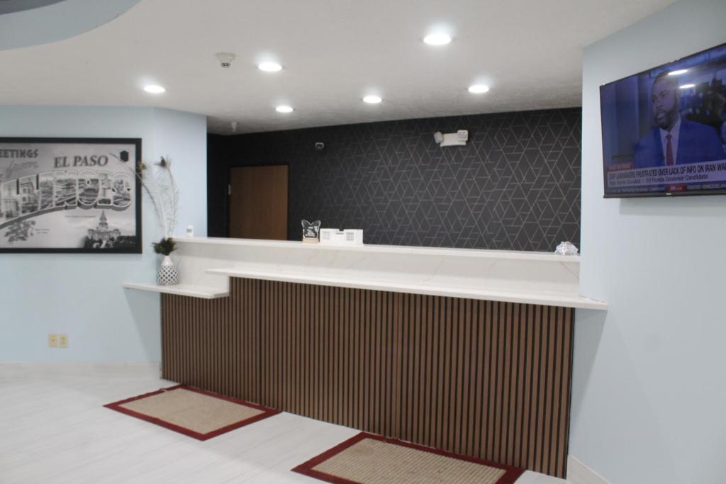 a hotel lobby with a reception counter and a television at Burgundy Inn & Suites in El Paso