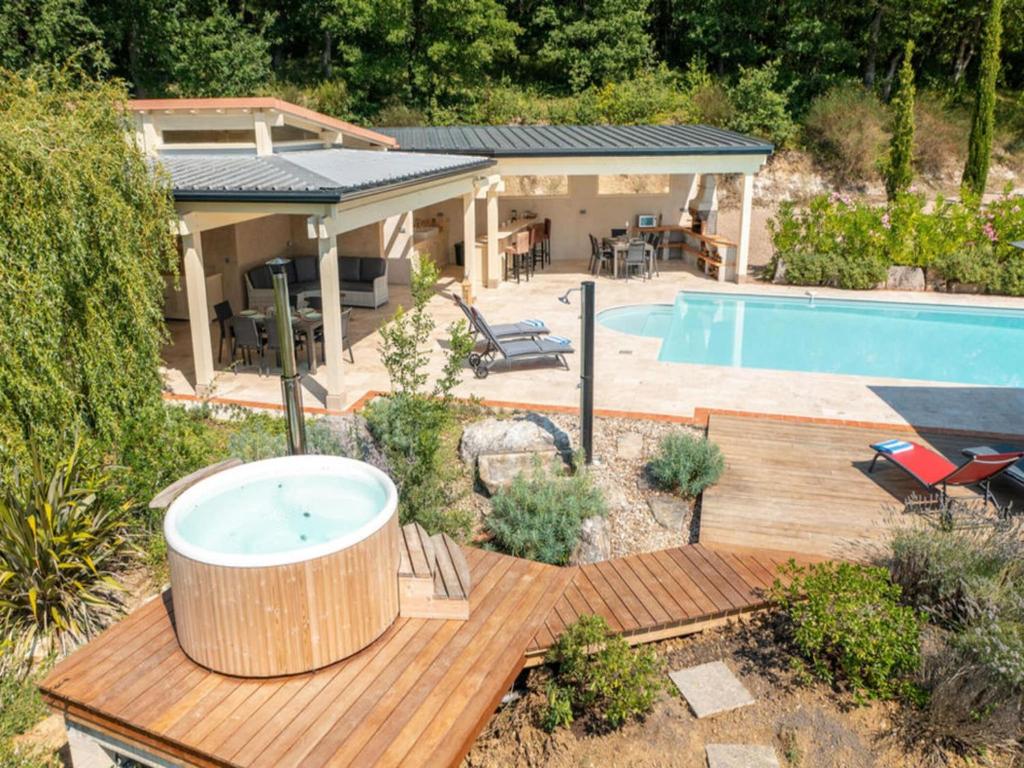 a hot tub on a wooden deck next to a pool at French Villa with Pool & Games Room in Damiatte