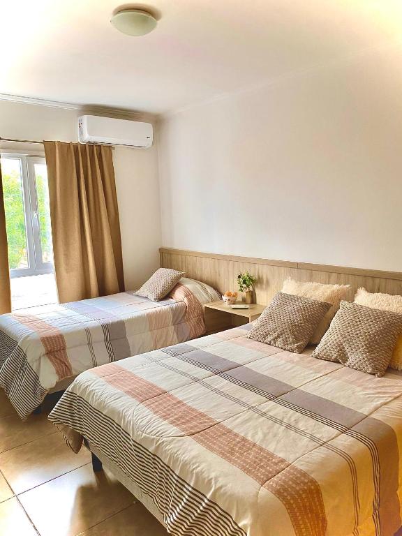 a hotel room with two beds and a window at Complejo Pampa 1 in Santa Rosa