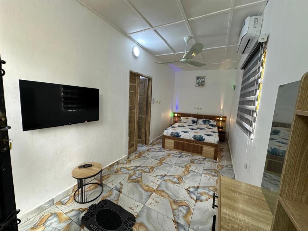 a bedroom with a bed and a flat screen tv at Jajoux Homes in Azohoué-Hiho