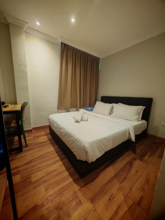 a bedroom with a large bed with white sheets at Swing & Pillows - Dataran Nilai in Nilai