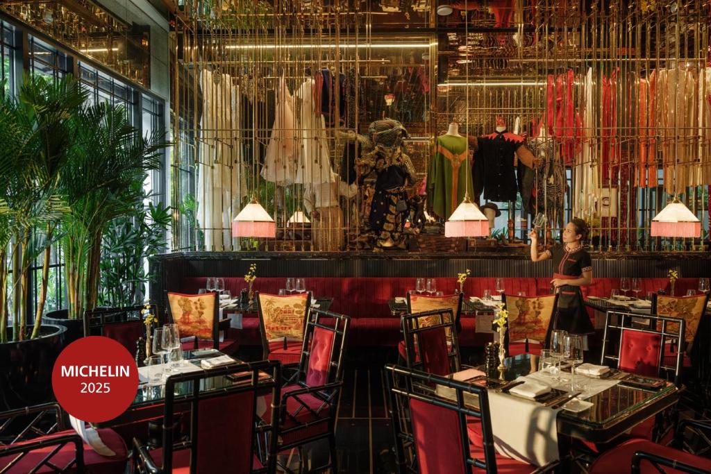 a restaurant with tables and chairs and a display of clothes at Capella Hanoi in Hanoi