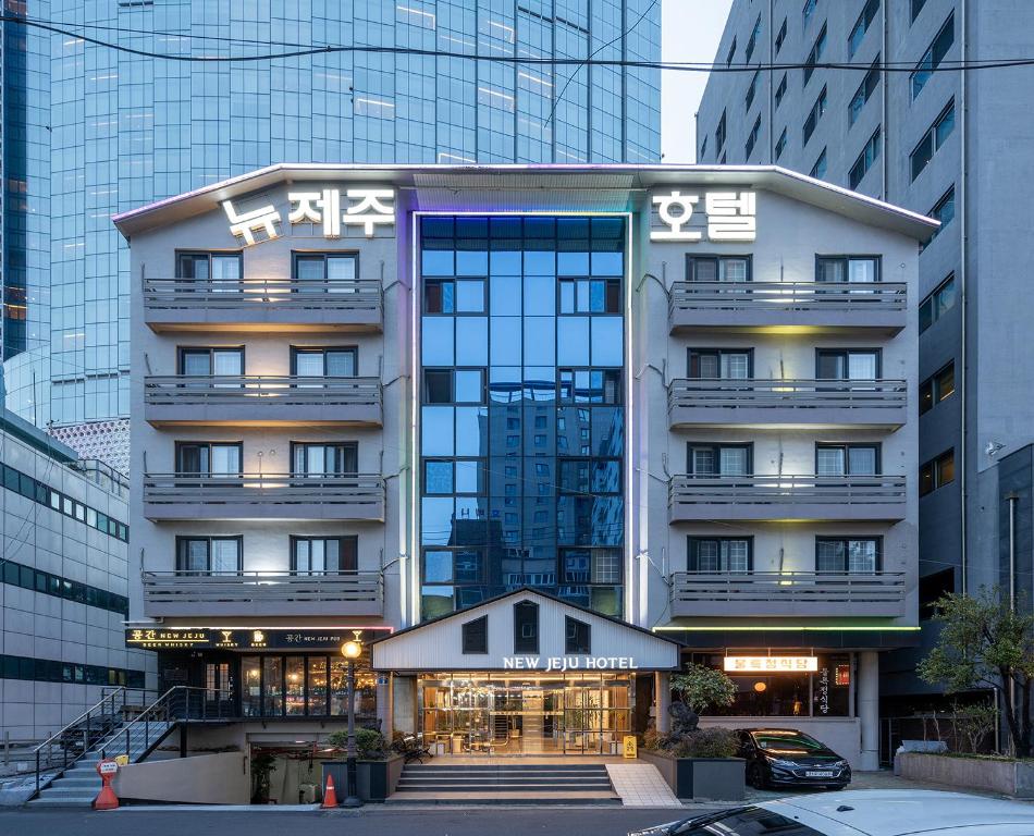 a large building with writing on it in a city at New Jeju Hotel in Jeju