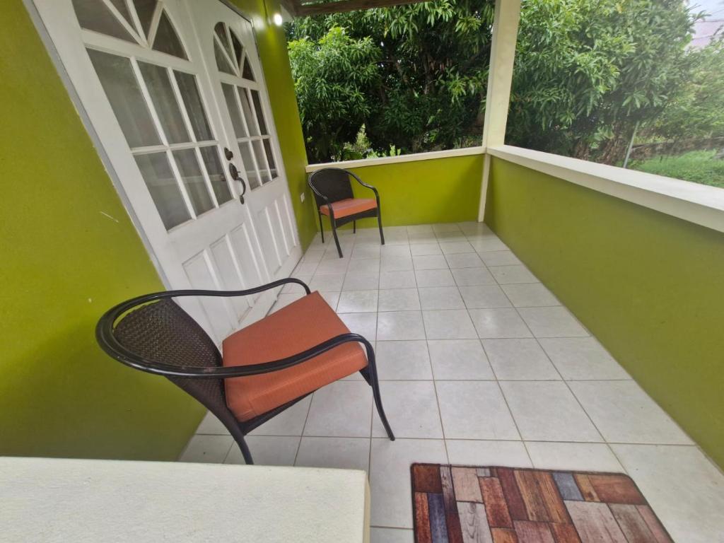 a porch with two chairs and a table at Pleasant House in Mount Pleasant
