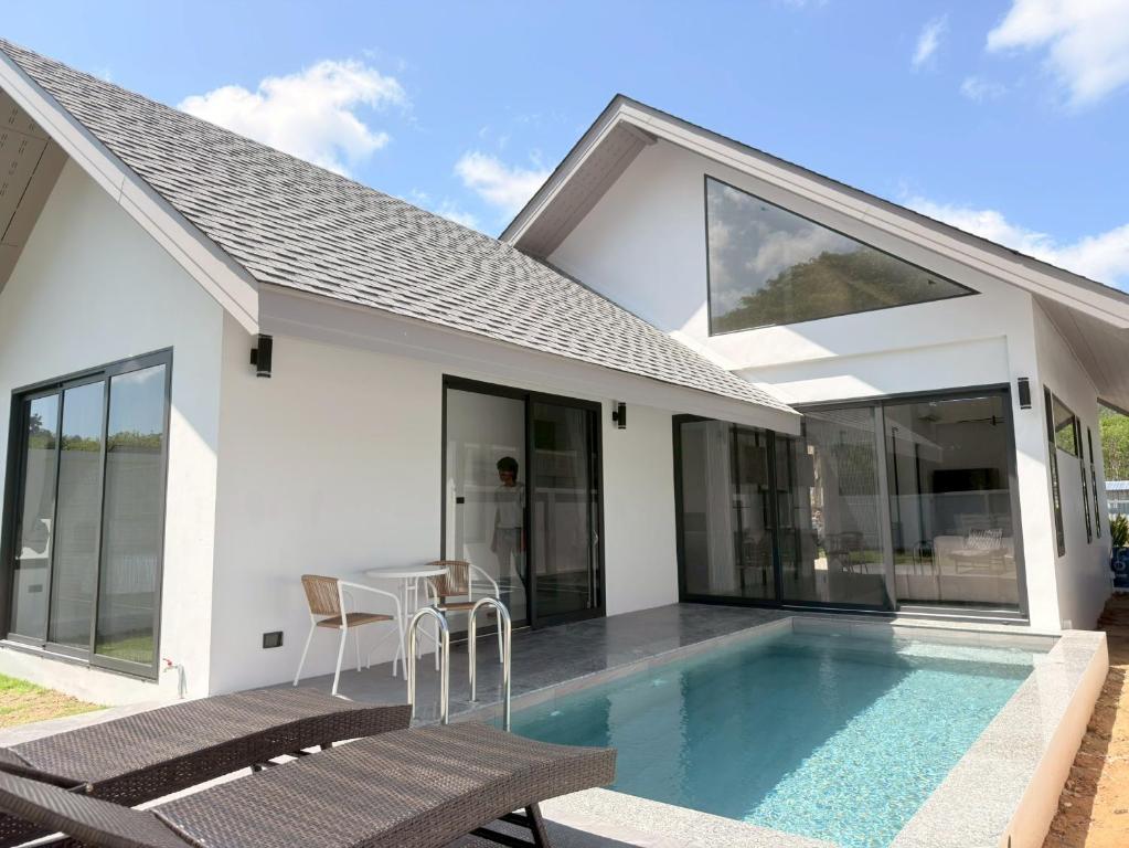 a villa with a swimming pool and a house at Akara Poolvilla Naithon Beach in Ban Sakhu