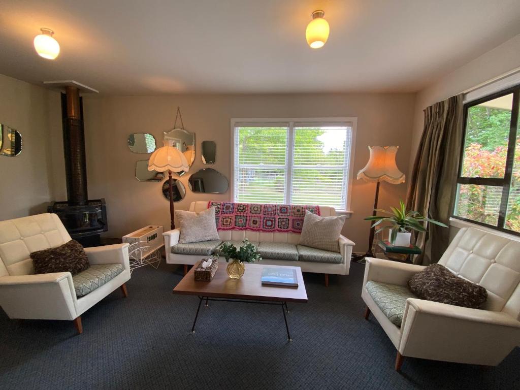a living room with couches and a table at Omarama township location - how good! in Omarama