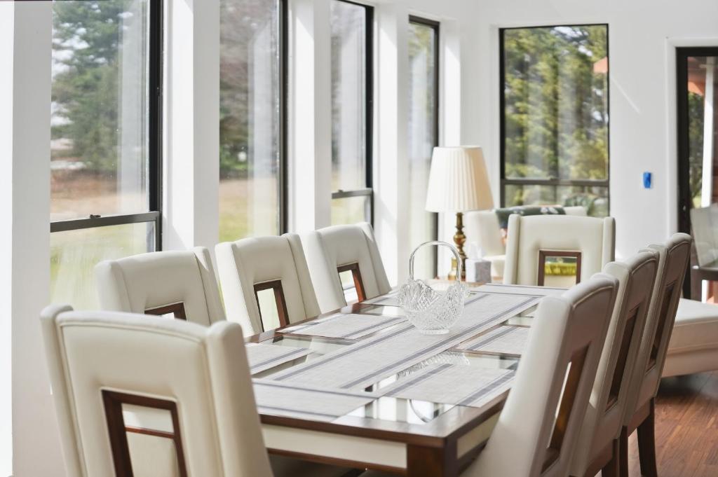 a dining room with a table and chairs and windows at Summit Sanctuary with EV Ready Mountain Views in Poughkeepsie