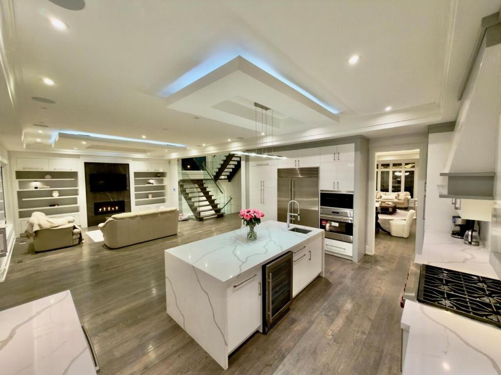 a kitchen with a white island in a living room at Modern Luxury Living in Toronto