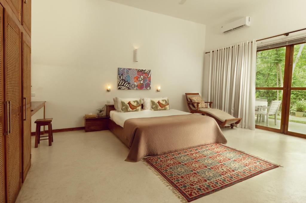 a bedroom with a large bed and a window at The Glasshouse Victoria in Digana