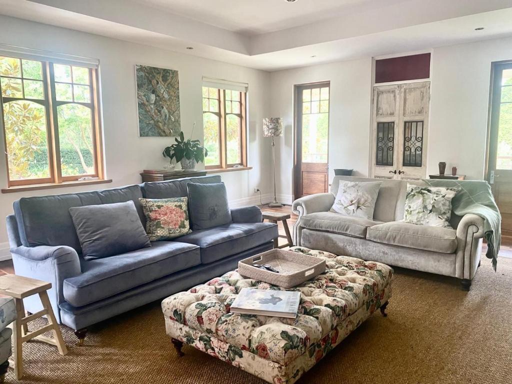 a living room with two couches and a coffee table at The Secret Garden Burradoo in Burradoo
