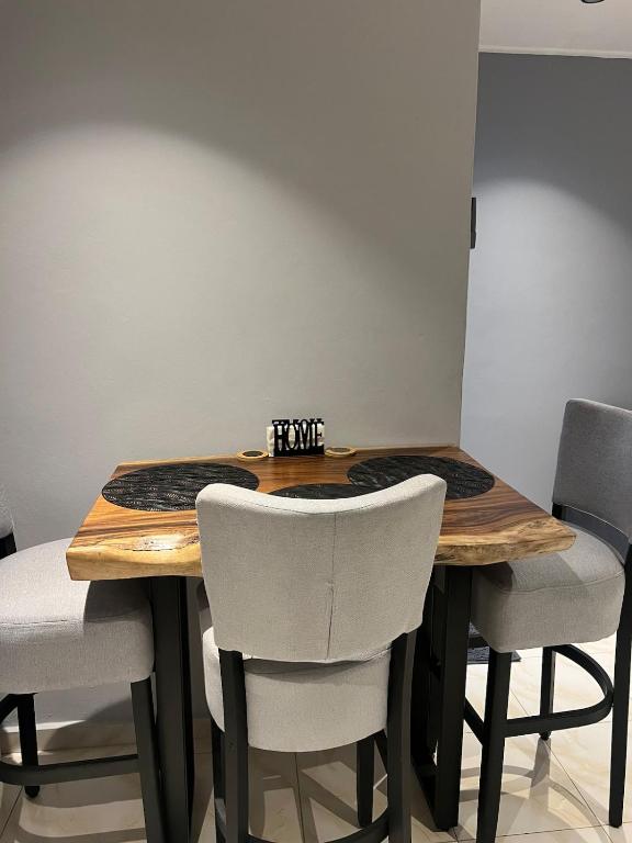 a dining room table with four chairs around it at Grey-B Appartment in Dorp Sint Michiel