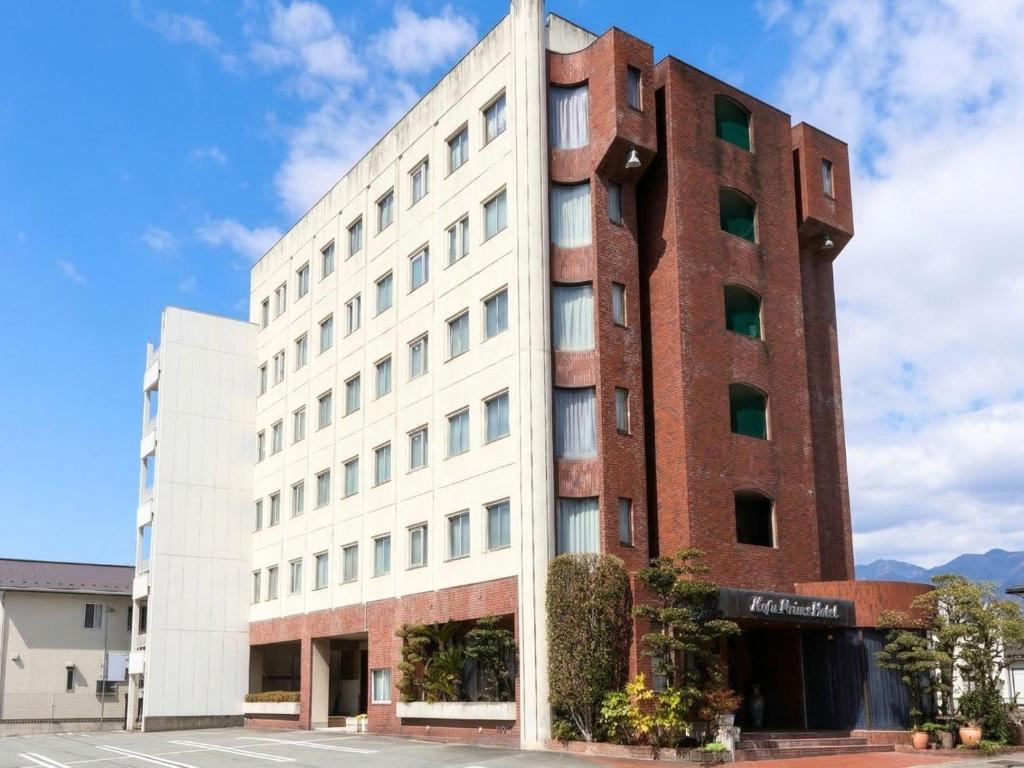 a tall white building with a brick at Asahikan in Kofu