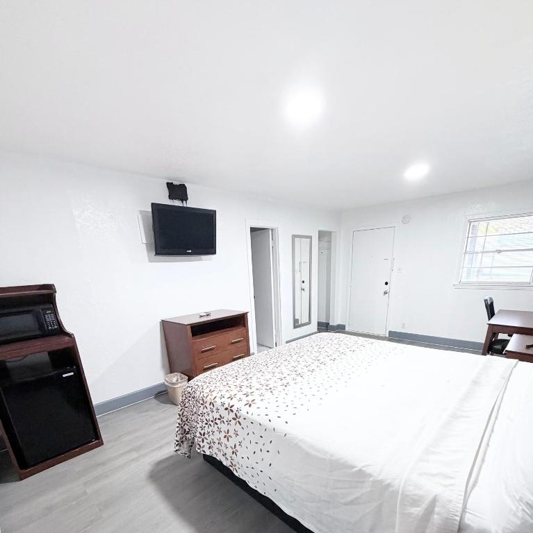 a bedroom with a bed and a tv on the wall at Economy Inn in Longview