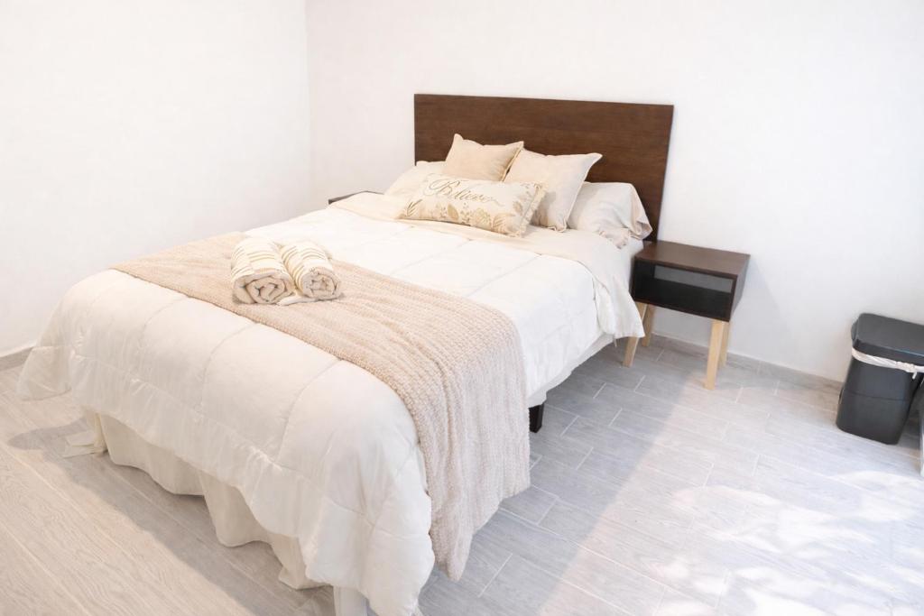 a bedroom with a large bed with white sheets at Luke Stay in El Pueblito