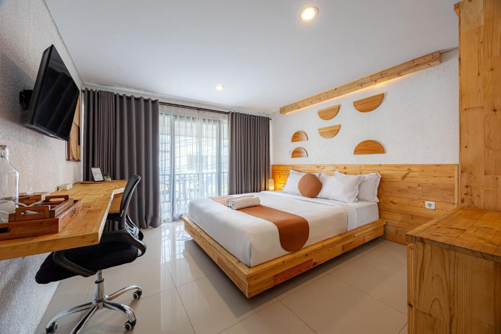 a bedroom with a bed and a desk and a computer at Cove Wong Village in Tumbak Bayuh