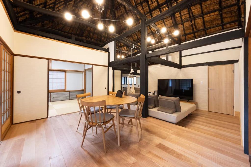 a dining room with a table and chairs and a couch at 将軍の隠れ家 in Okayama