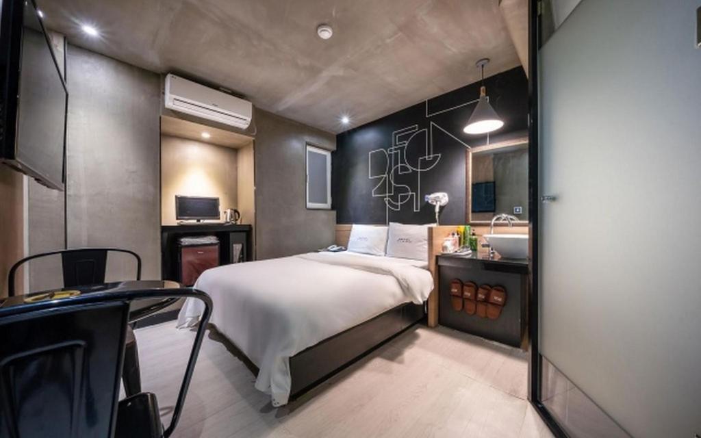 a bedroom with a bed and a sink in it at Hotel Piano in Seoul