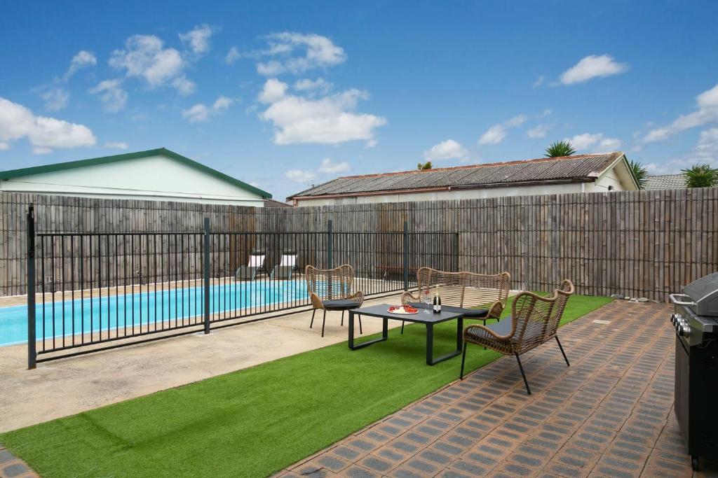 a patio with a table and chairs next to a pool at Coastal Blue in Windang
