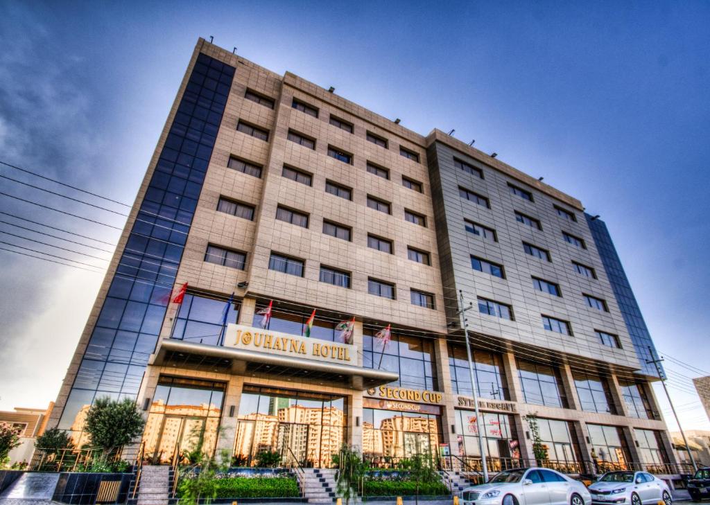 a large building with cars parked in front of it at Jouhayna Hotel&Suite in Erbil