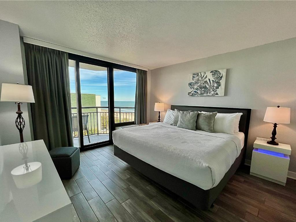 a bedroom with a large bed and a balcony at Captivating Coastal Charm - Oceanview Suite! PG 504 in Myrtle Beach