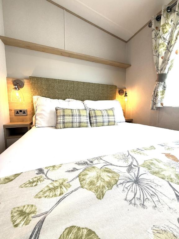 a bedroom with a large white bed with leaves on it at Cedar Retreat in Scarborough