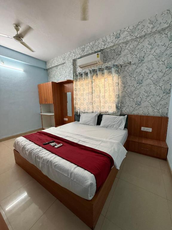 a bedroom with a large bed with a red blanket at Hotel Sutlaj in Indore