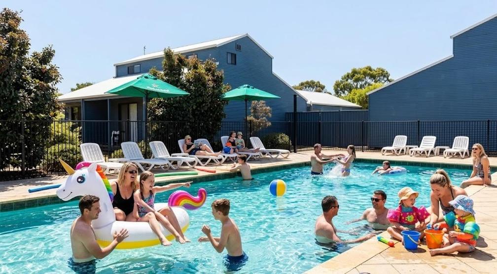 a group of people playing in a swimming pool at Townhouse 7 - Located at FOOTPRINTS PRESTON BEACH RESORT in Preston Beach