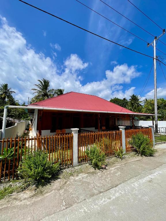 a building with a red roof and a fence at Anugerah's House in Katiet