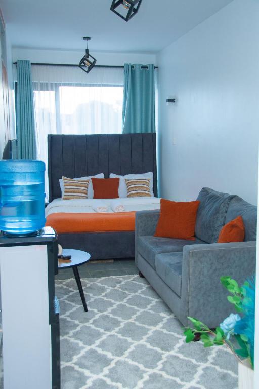 a living room with a couch and a bed at Hise Haven Stays in Kiambu