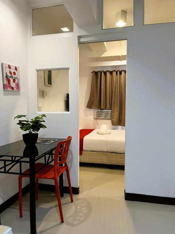 a room with a table and a bedroom with a bed at Makati One Poblacion Hotel in Manila