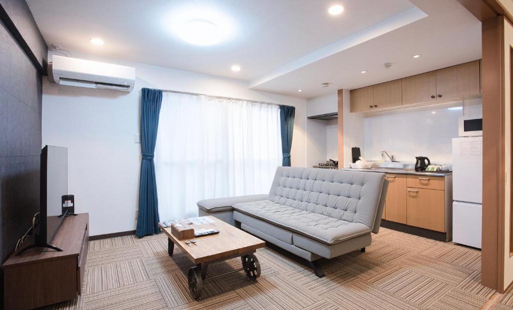 a living room with a couch and a table at Shinka Hotel Susukino in Sapporo