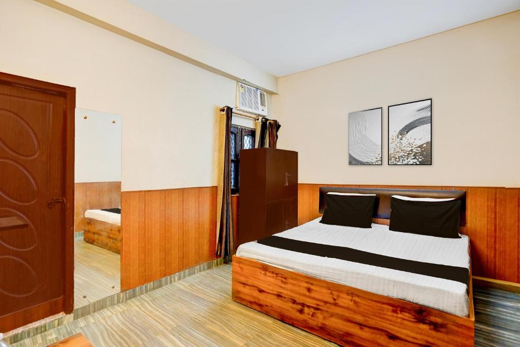 a bedroom with a bed with a wooden headboard at Super Hotel O Dehradun City Centre Formerly Downtown in Dehradun