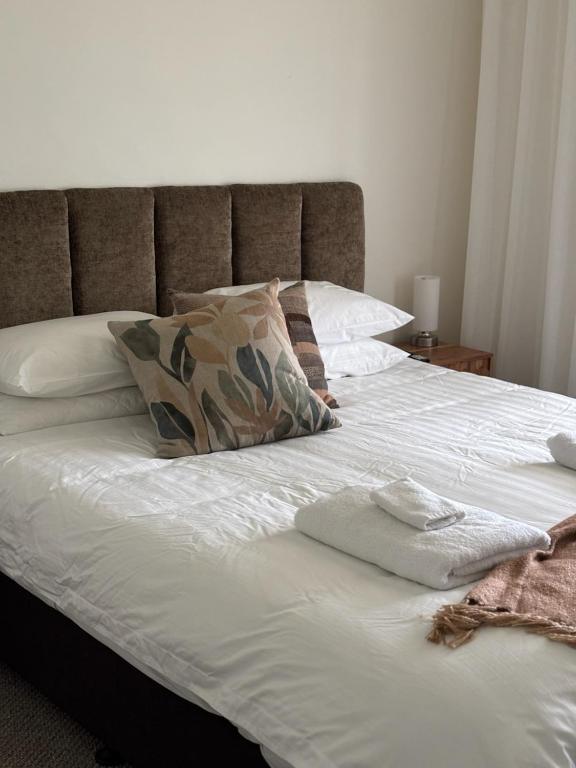 a bed with white sheets and pillows on it at Annabelle's Cottage in Clare