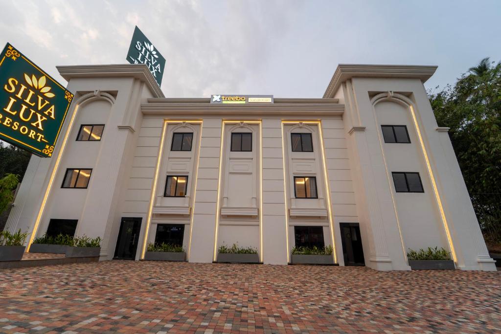 a white building with a sign in front of it at Treebo Premium Silva Lux in Wayanad
