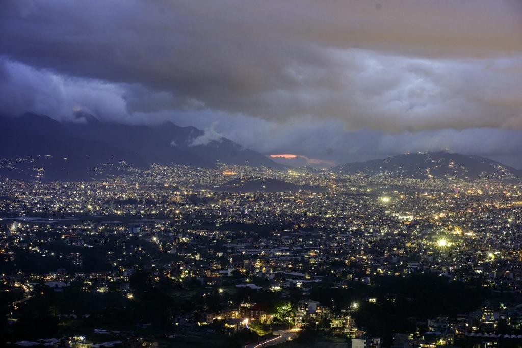 a view of a city at night with a mountain at Lamatar Hills Resort in Pātan